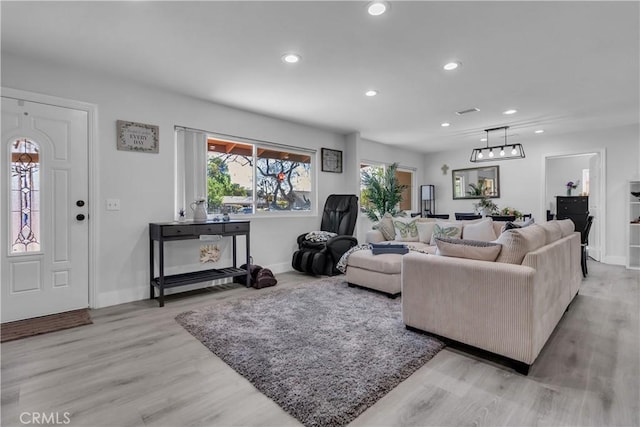 living room with light wood-style flooring, baseboards, and recessed lighting