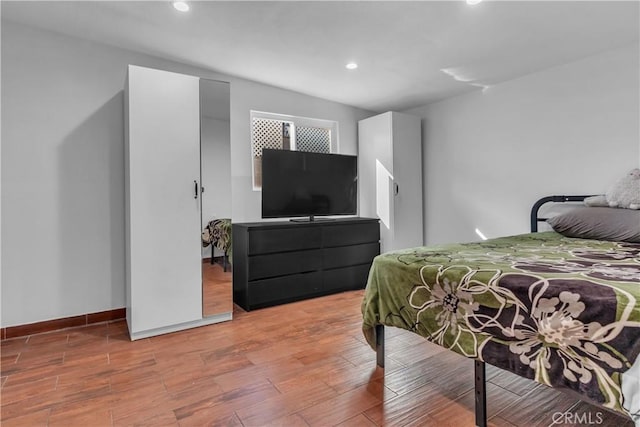 bedroom with recessed lighting, baseboards, and wood finished floors