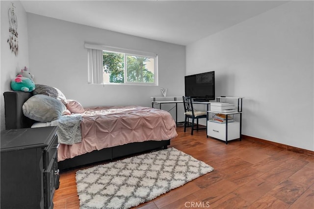 bedroom with wood finished floors and baseboards