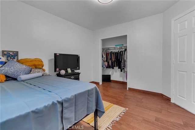 bedroom featuring a closet, baseboards, and wood finished floors