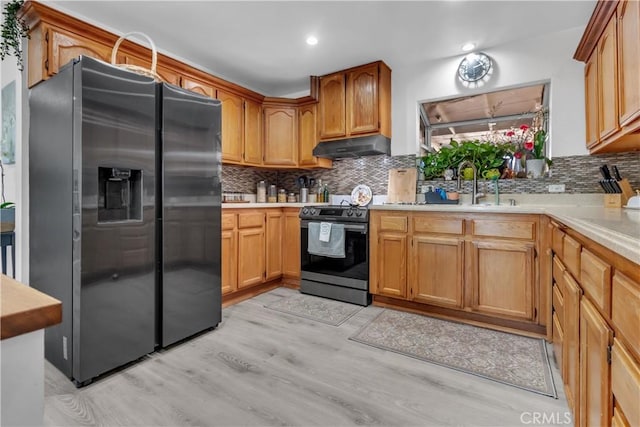 kitchen with electric stove, light countertops, decorative backsplash, under cabinet range hood, and stainless steel fridge with ice dispenser