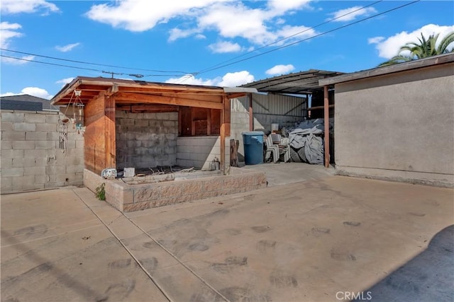 view of patio with an outbuilding and fence