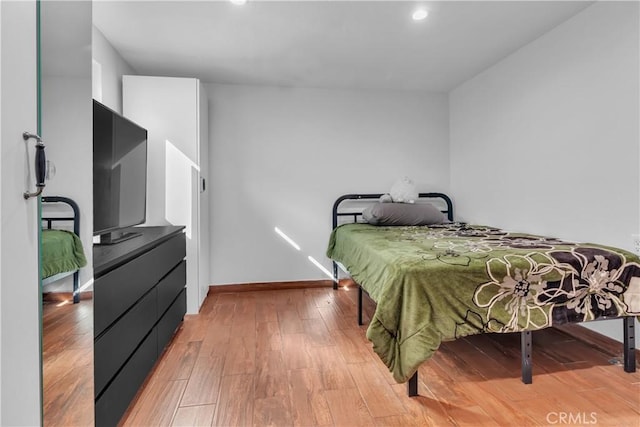 bedroom featuring baseboards and wood finished floors