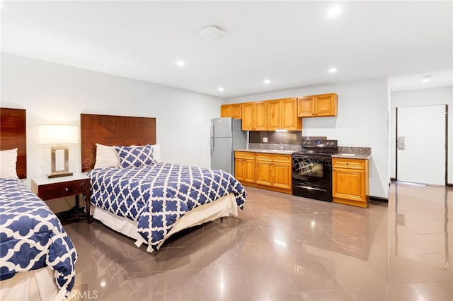 bedroom featuring freestanding refrigerator, a sink, and recessed lighting