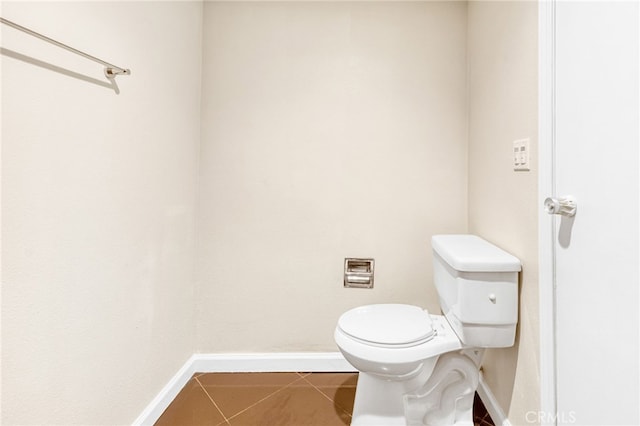 bathroom with tile patterned flooring, toilet, and baseboards