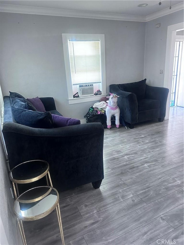 living room featuring cooling unit, crown molding, and wood finished floors