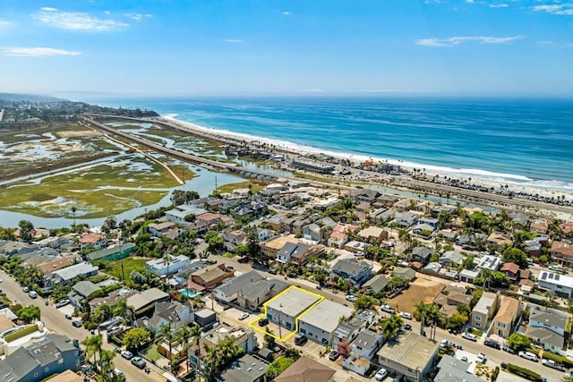 bird's eye view with a water view, a view of the beach, and a residential view