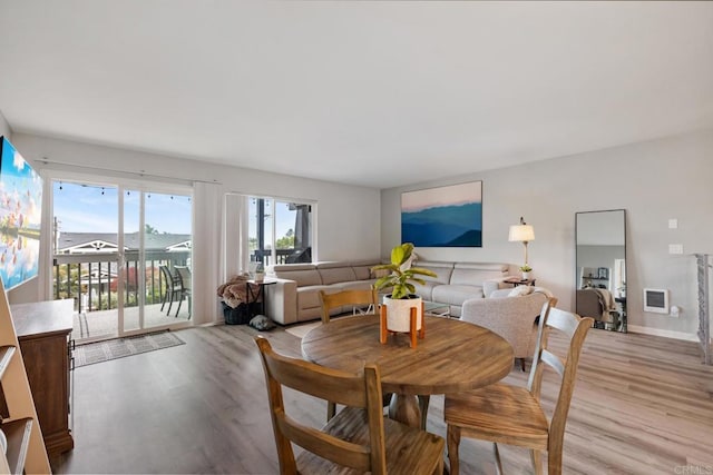 dining area featuring light wood finished floors and baseboards