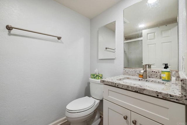 bathroom featuring an enclosed shower, vanity, and toilet