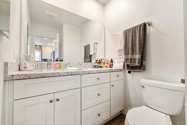 full bathroom with double vanity, a sink, visible vents, and toilet