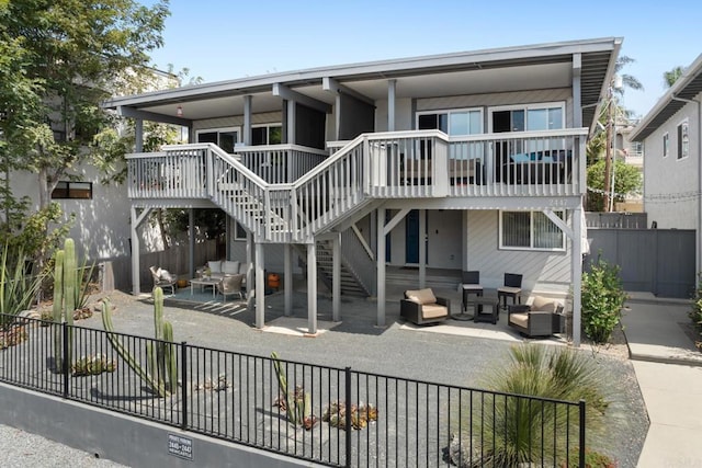 rear view of house with a patio area, stairs, fence, and an outdoor hangout area