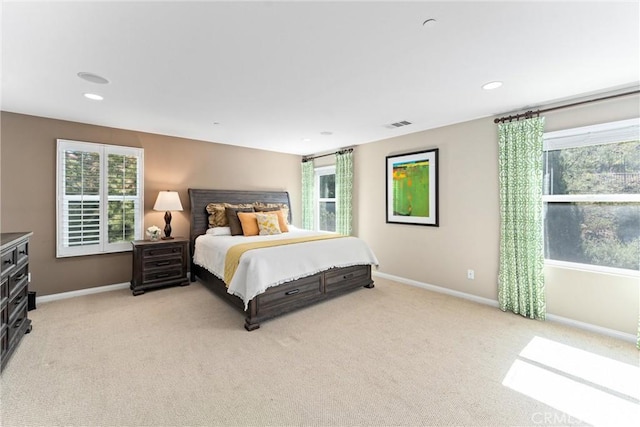 bedroom with light carpet, multiple windows, recessed lighting, and baseboards