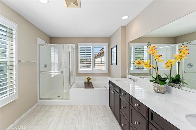 bathroom with double vanity, a stall shower, visible vents, a sink, and a bath