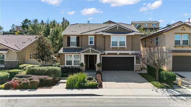 craftsman house featuring a garage, driveway, a tiled roof, and stucco siding