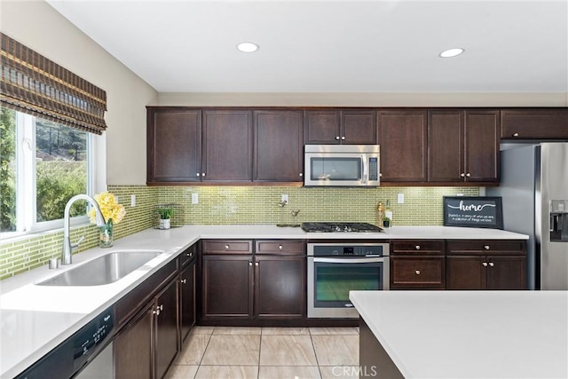 kitchen with stainless steel appliances, a sink, and light countertops