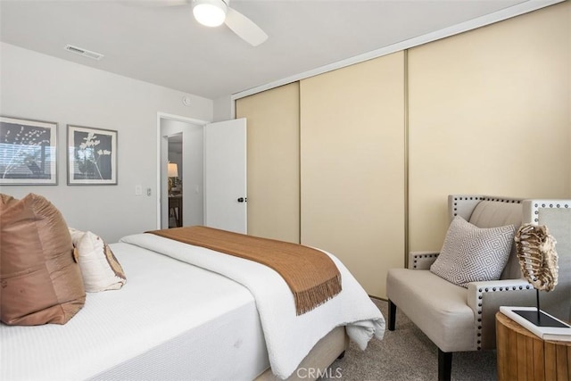 bedroom featuring carpet floors, a ceiling fan, visible vents, and a closet