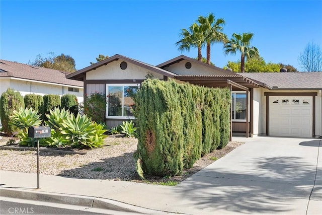 view of front of home featuring a garage, driveway, and stucco siding