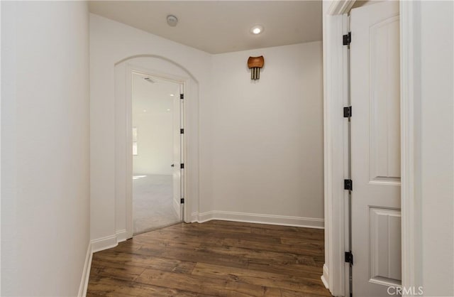 corridor featuring dark wood finished floors and baseboards