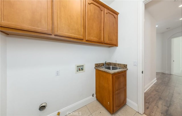 washroom featuring hookup for a washing machine, hookup for a gas dryer, cabinet space, a sink, and baseboards