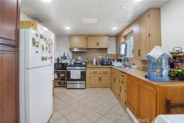 8181 Date St, Fontana, CA 92335 - kitchen with freestanding refrigerator, light countertops, under cabinet range hood, black microwave, and stainless steel range with gas stovetop