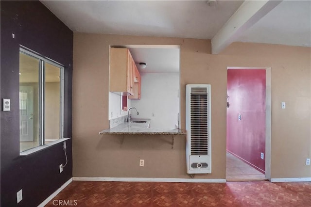 8181 Date St, Fontana, CA 92335 - kitchen featuring baseboards, a heating unit, light countertops, light brown cabinetry, and a sink