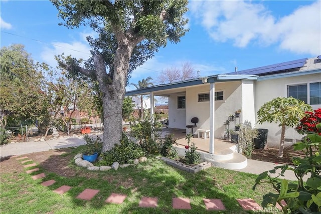 8181 Date St, Fontana, CA 92335 - rear view of property featuring roof mounted solar panels, a patio area, fence, and stucco siding