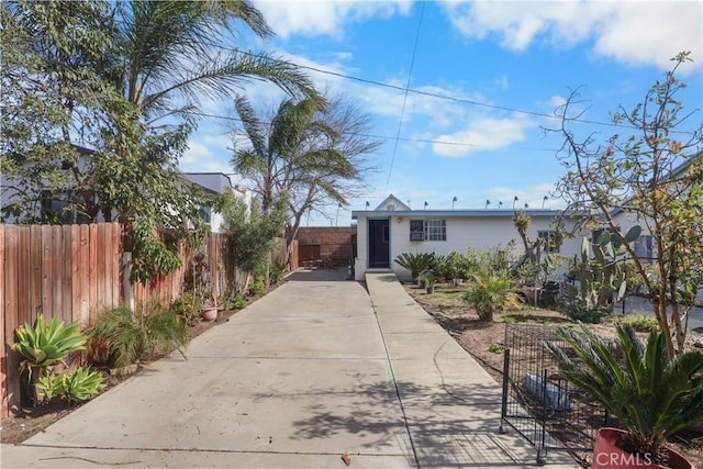 view of front of house featuring concrete driveway and fence