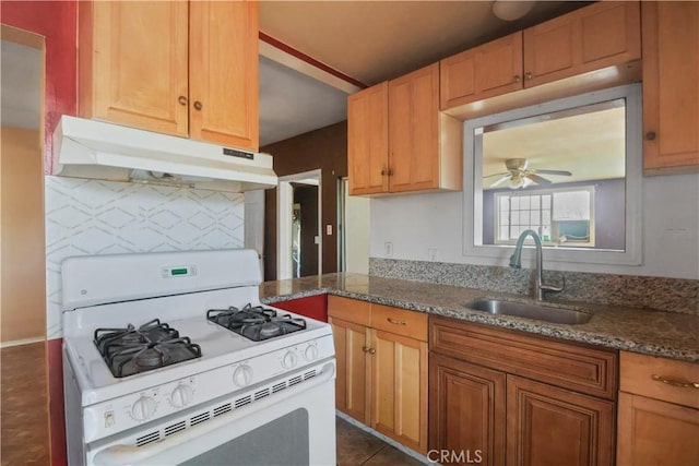 8181 Date St, Fontana, CA 92335 - kitchen featuring stone countertops, under cabinet range hood, white range with gas stovetop, a sink, and a ceiling fan