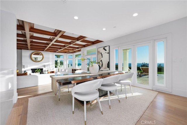 dining room featuring recessed lighting, coffered ceiling, a fireplace, and wood finished floors