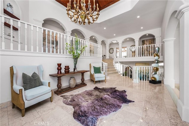 living area featuring marble finish floor, decorative columns, an inviting chandelier, and recessed lighting