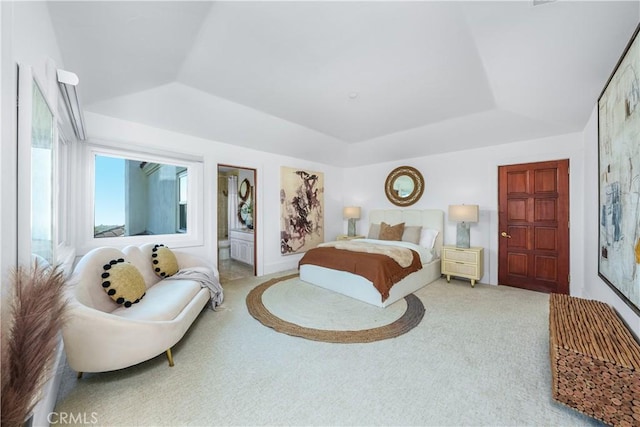 carpeted bedroom with lofted ceiling and a raised ceiling