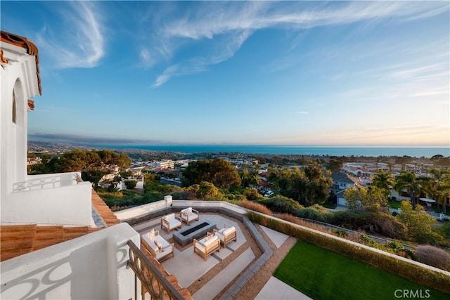 balcony featuring a water view, a patio, and a fire pit