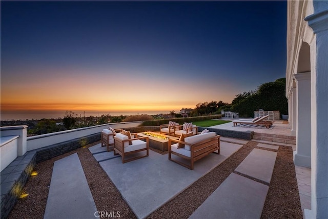 patio terrace at dusk featuring an outdoor living space with a fire pit