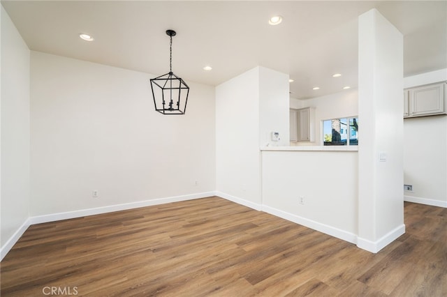 spare room featuring recessed lighting, wood finished floors, and baseboards