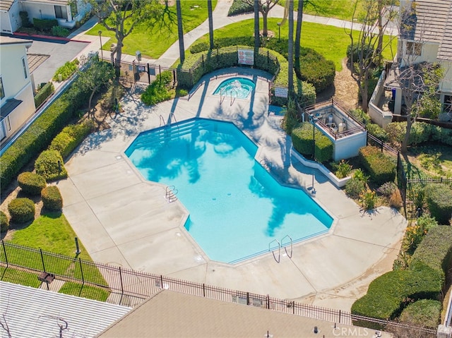 community pool with fence and a patio