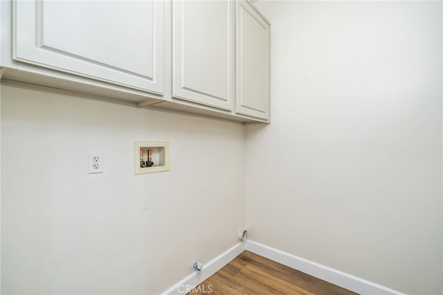 laundry room with cabinet space, hookup for a washing machine, baseboards, and wood finished floors