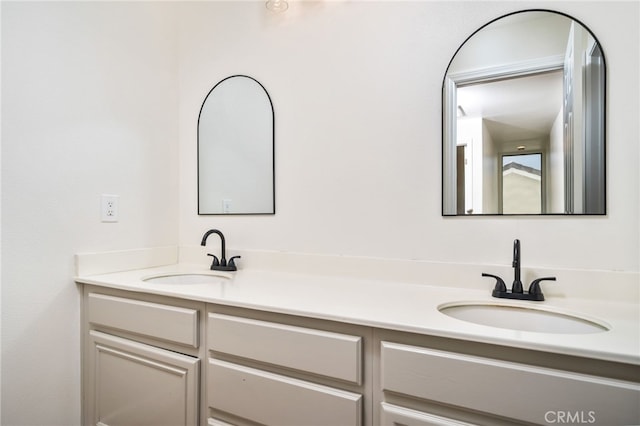 full bathroom with double vanity and a sink