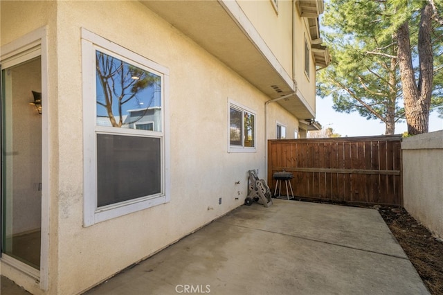 view of home's exterior featuring a patio area, fence, and stucco siding