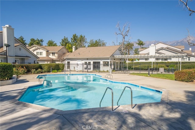 pool with a residential view, fence, and a patio