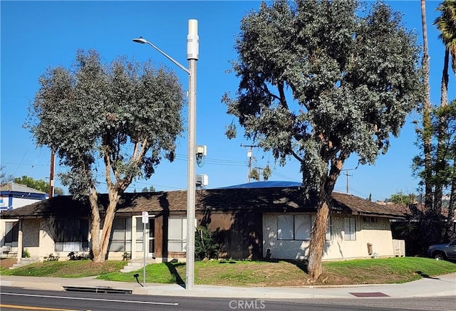 view of front facade featuring a front yard and stucco siding