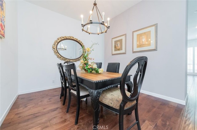 dining space with an inviting chandelier, wood finished floors, and baseboards