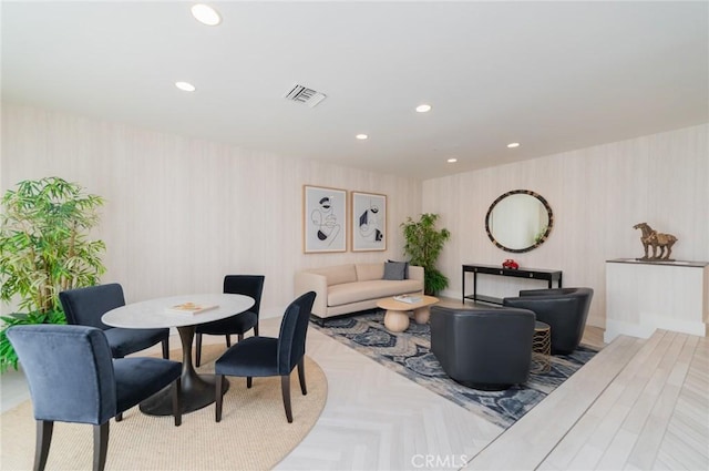 living area with wallpapered walls, visible vents, and recessed lighting