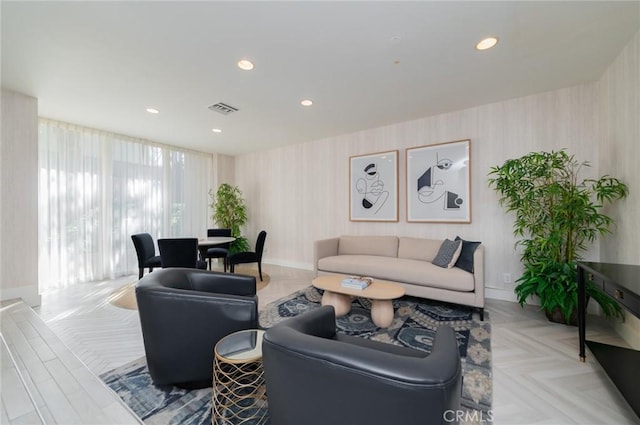 living area with recessed lighting, visible vents, and baseboards