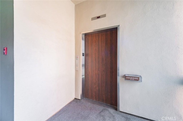 doorway to property with stucco siding and elevator