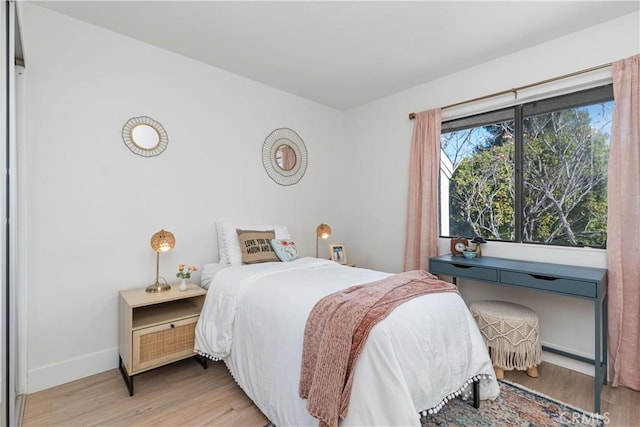 bedroom with baseboards and light wood finished floors