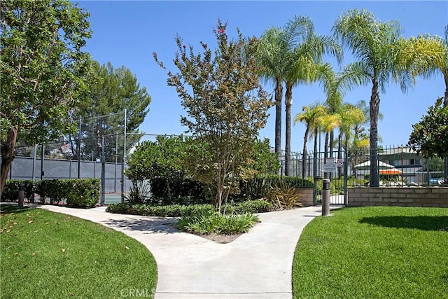 view of community with a lawn and fence