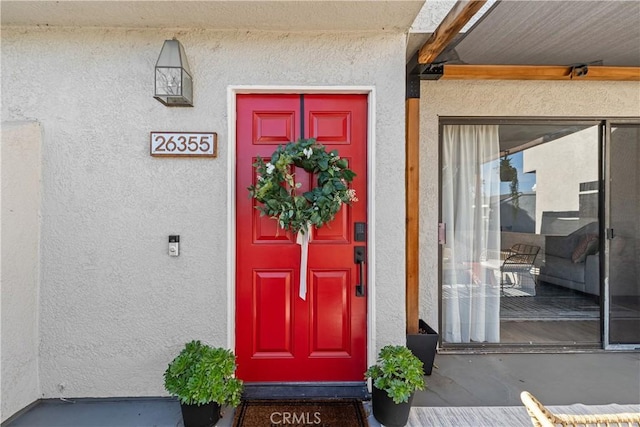 doorway to property featuring stucco siding