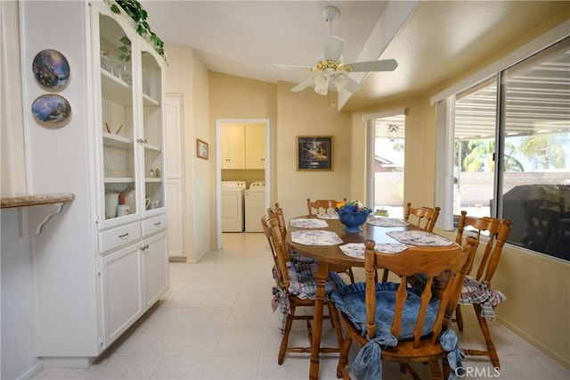dining area with light tile patterned flooring, ceiling fan, washing machine and dryer, and lofted ceiling