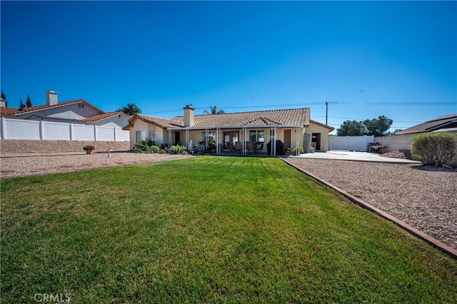 ranch-style home featuring a tiled roof, a front lawn, a patio area, and stucco siding