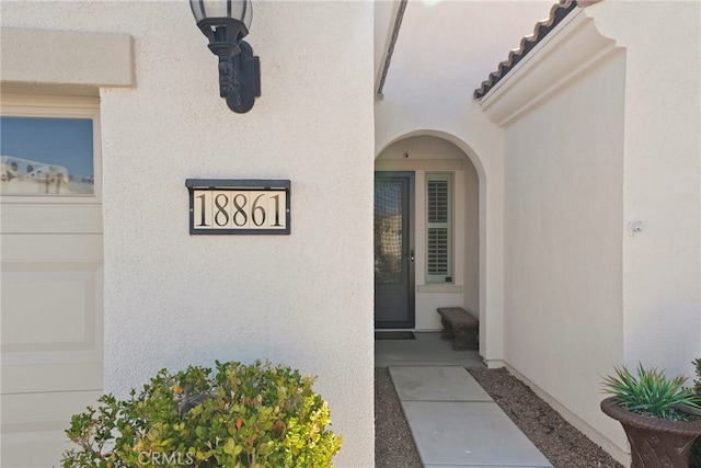 entrance to property featuring stucco siding